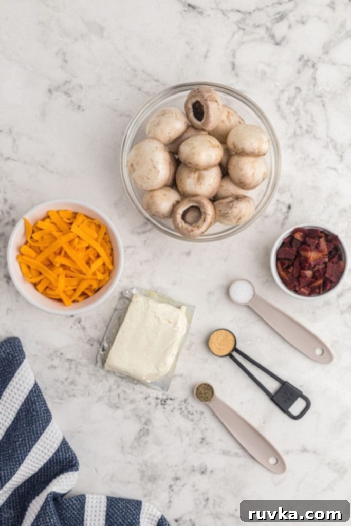 Ultimate Air Fryer Stuffed Mushrooms 3 Ingredients needed to make stuffed mushrooms measured in bowls and on a white marble table.