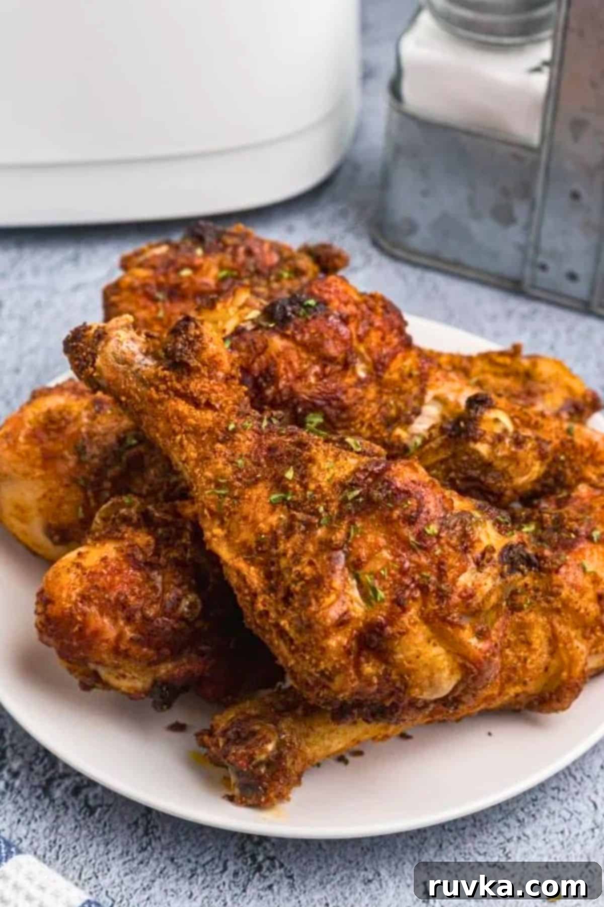 Crispy Air Fryer Drumsticks 8 uicy crusted chicken with seasonings served on a white plate