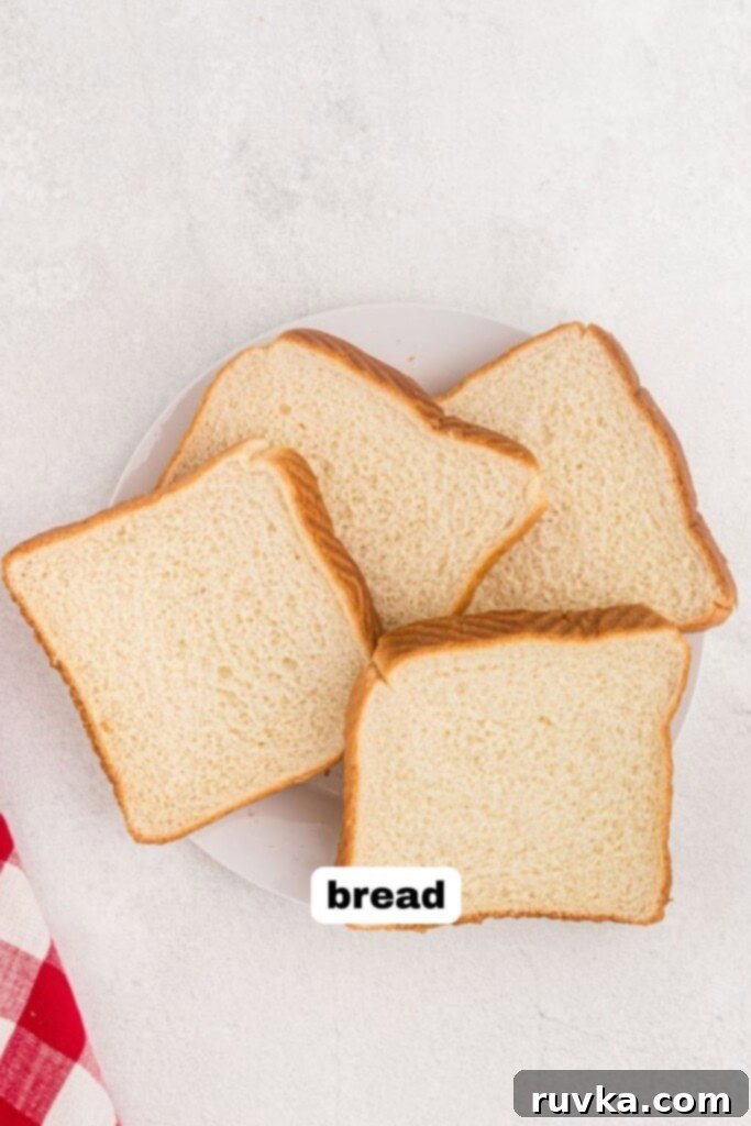 The Ultimate Air Fryer Toast 3 Plate of white bread slices on a white table before being toasted in the air fryer.
