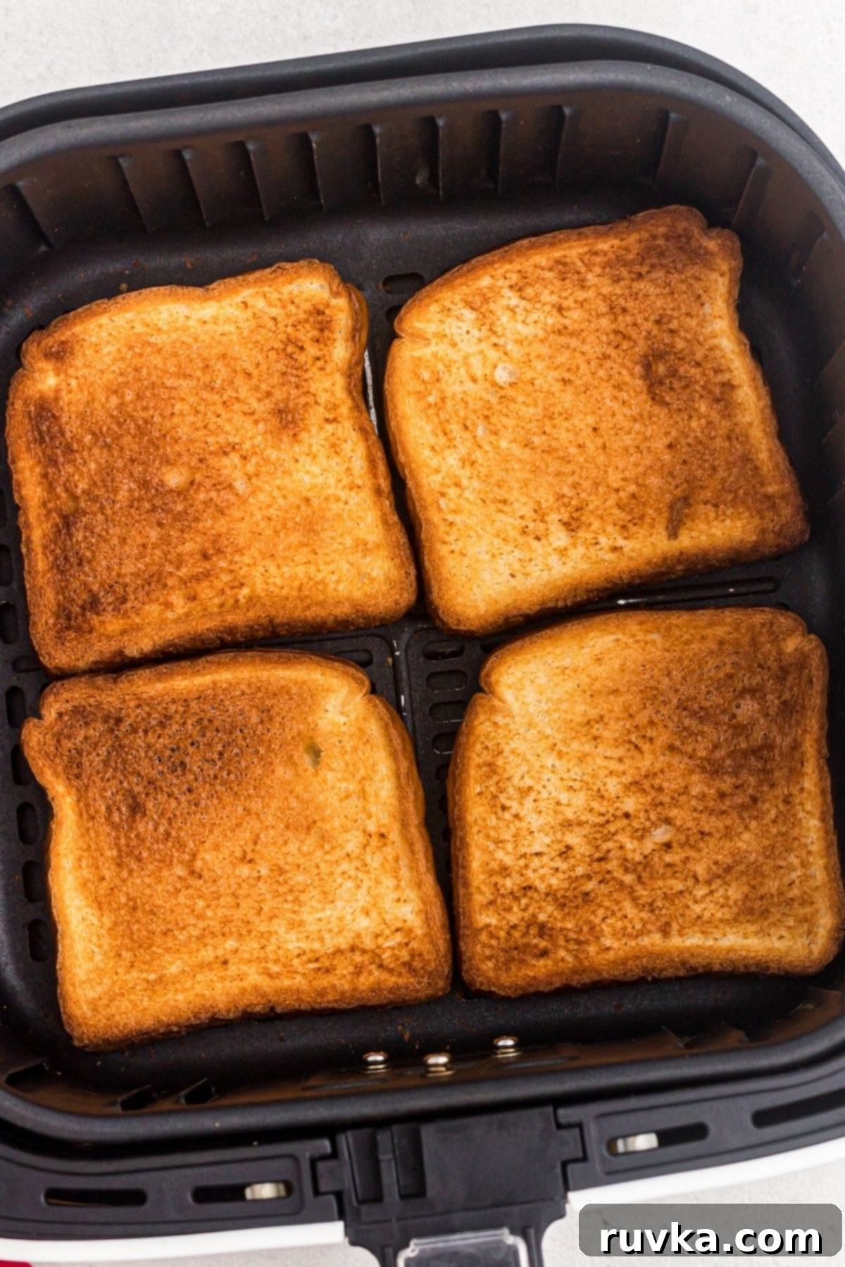 The Ultimate Air Fryer Toast 5 Four slices of golden toast after being cooked in the air fryer basket