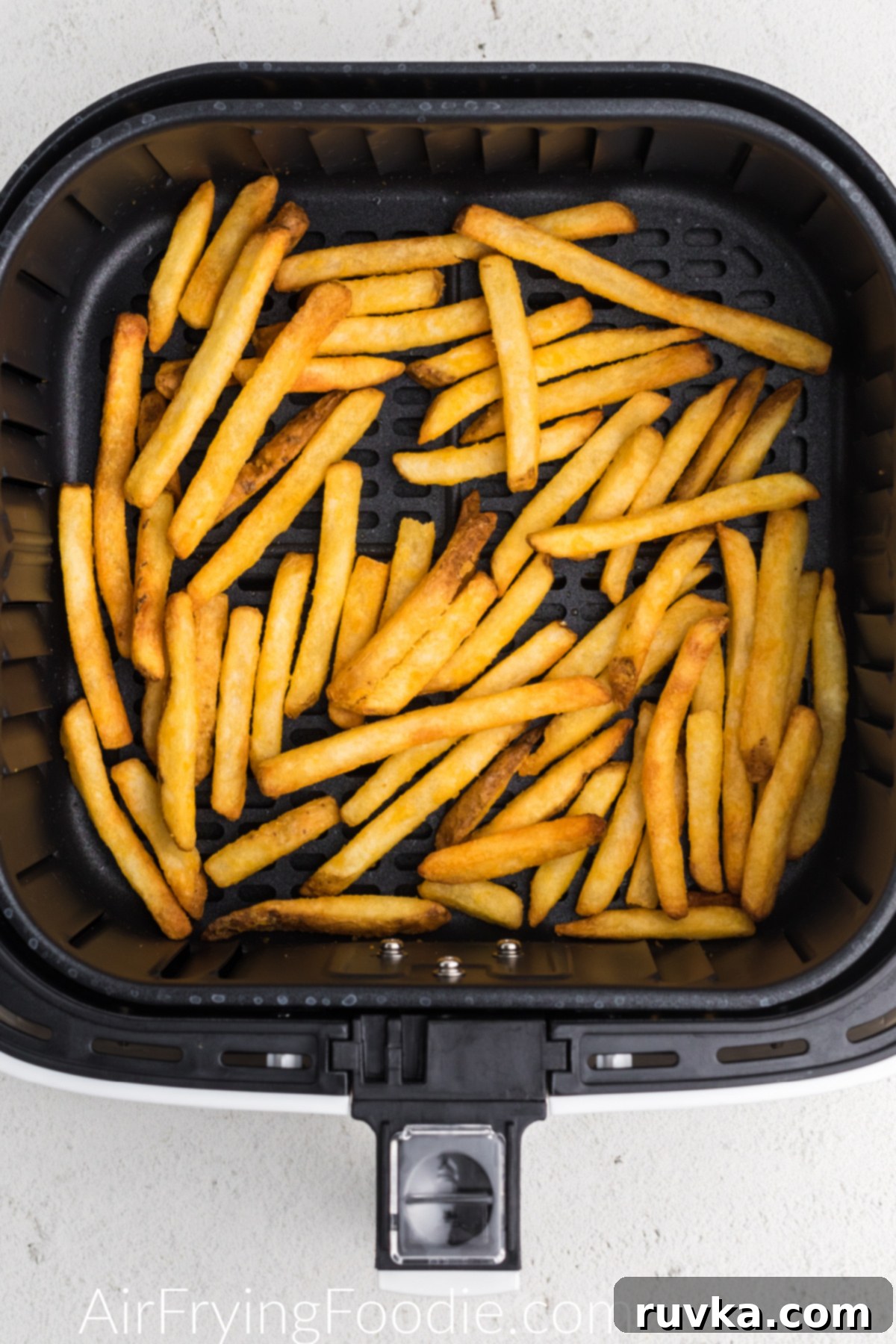 Crispy Air Fryer Frozen French Fries 5 Cooked, golden-brown French fries still in the air fryer basket after achieving perfect crispiness.