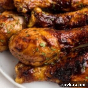 Crispy Air Fryer BBQ Chicken 8 Juicy BBQ coated chicken on a white plate garnished with parsley flakes