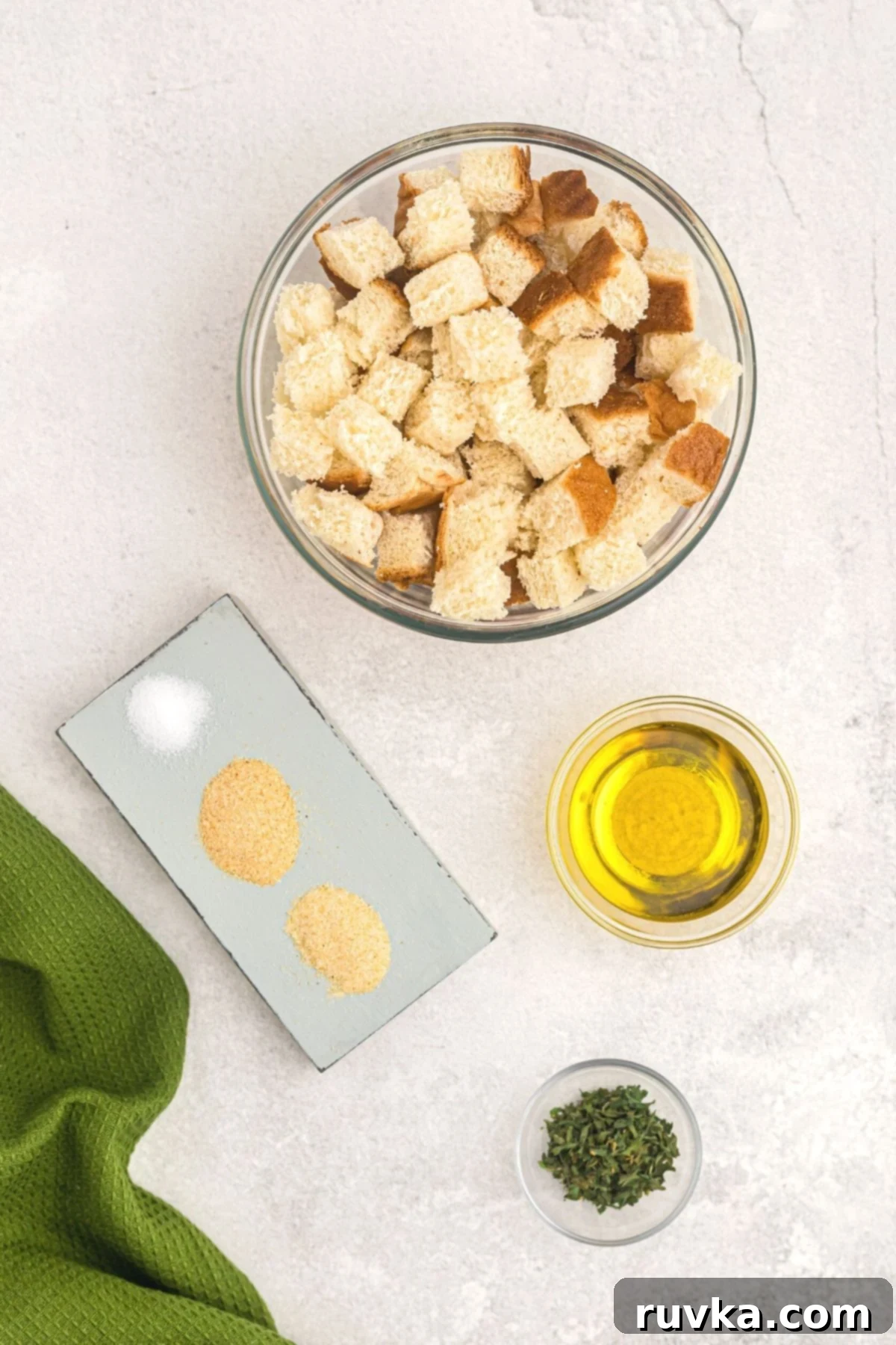Perfectly Crispy Air Fryer Croutons 3 Ingredients needed to make homemade croutons measured into small bowls on a marble table.