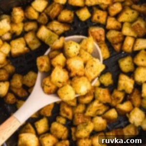 Perfectly Crispy Air Fryer Croutons 6 Spoonful of croutons being scooped out of the air fryer basket.