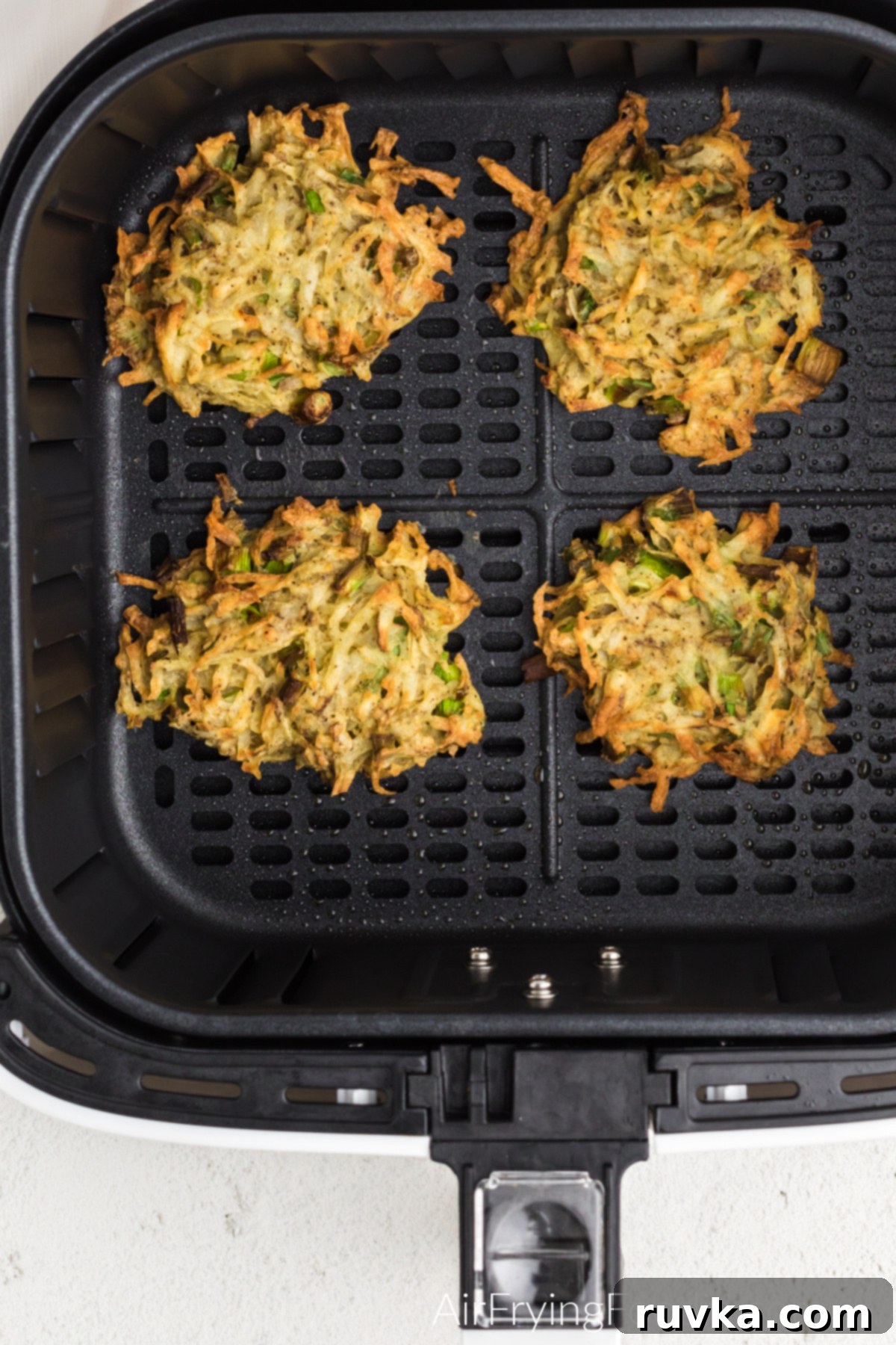 Crispy Air Fryer Latkes 8 Latkes in the air fryer basket ready to serve.