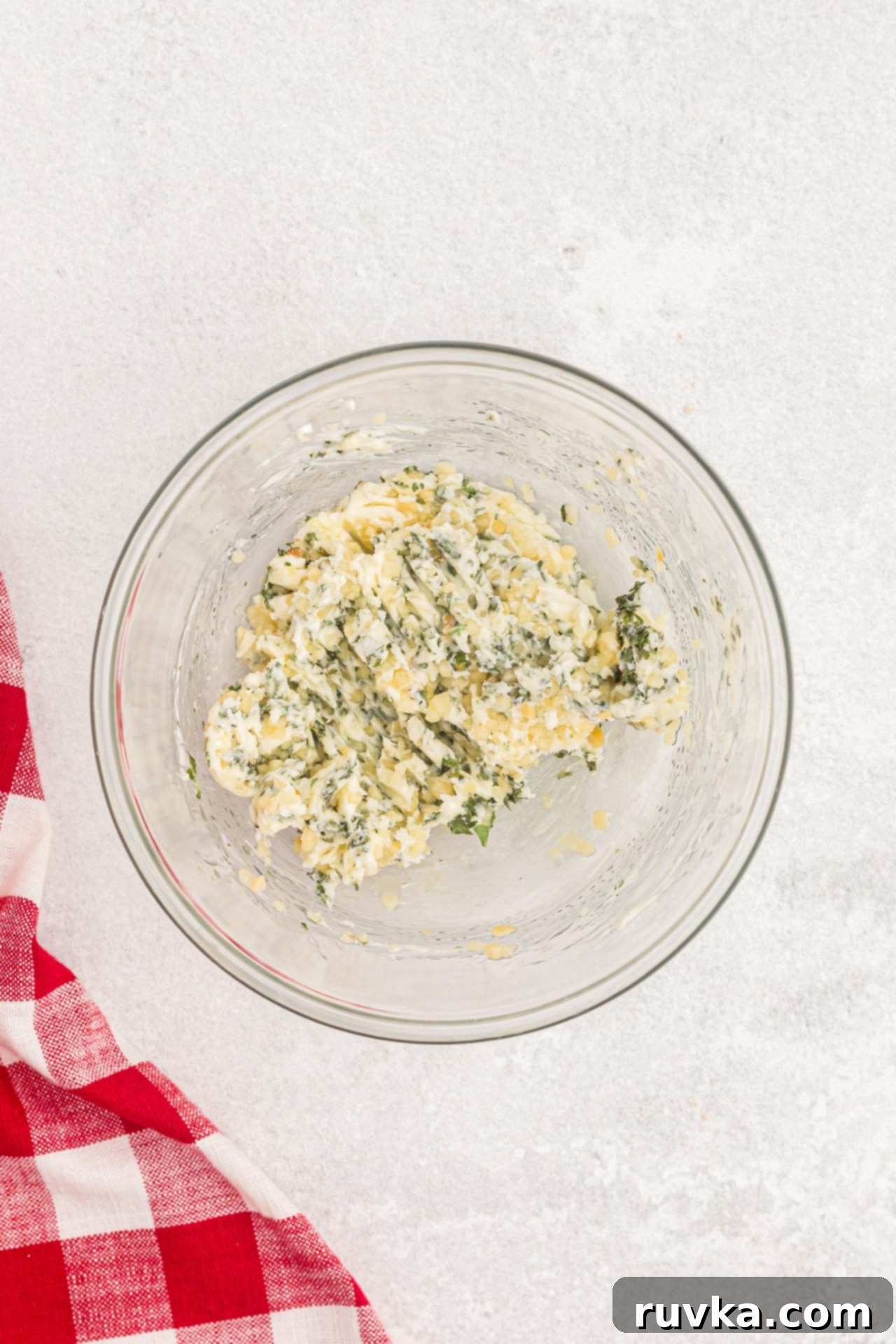 Perfect Air Fryer Garlic Bread 4 Butter, minced garlic, and parsley flakes mixed together in a clear glass bowl, ready to be spread.