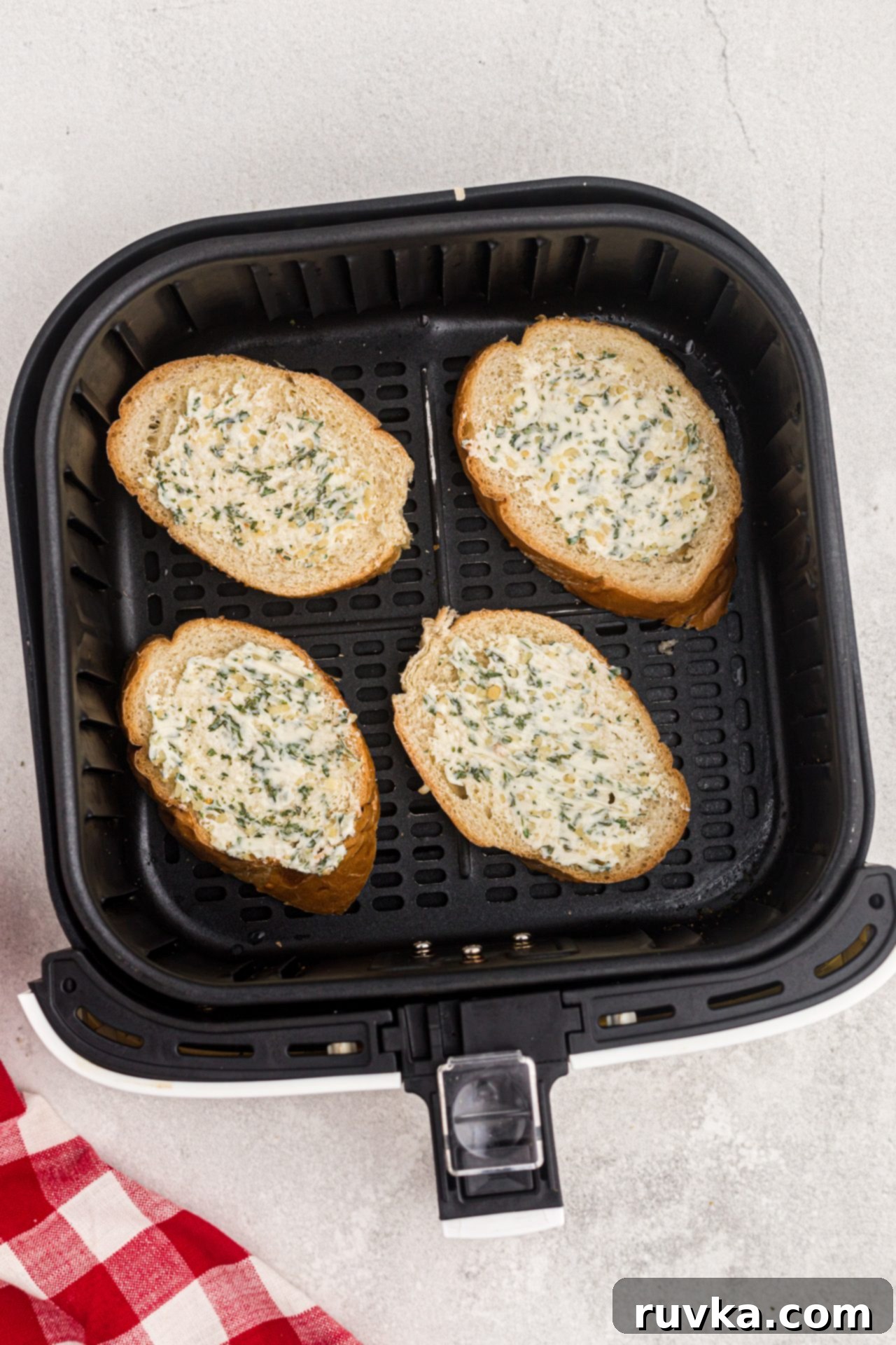 Perfect Air Fryer Garlic Bread 5 Buttered and seasoned bread slices arranged neatly in an air fryer basket, pre-cooking, showcasing the readiness for toasting.