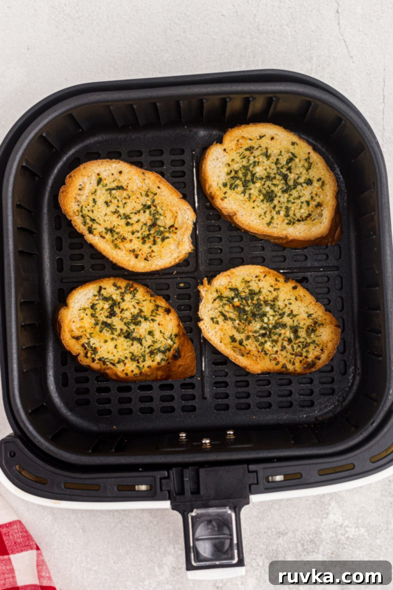 Perfect Air Fryer Garlic Bread 6 Crispy golden garlic bread slices glistening with melted butter and herbs, perfectly cooked and arranged in the air fryer basket.