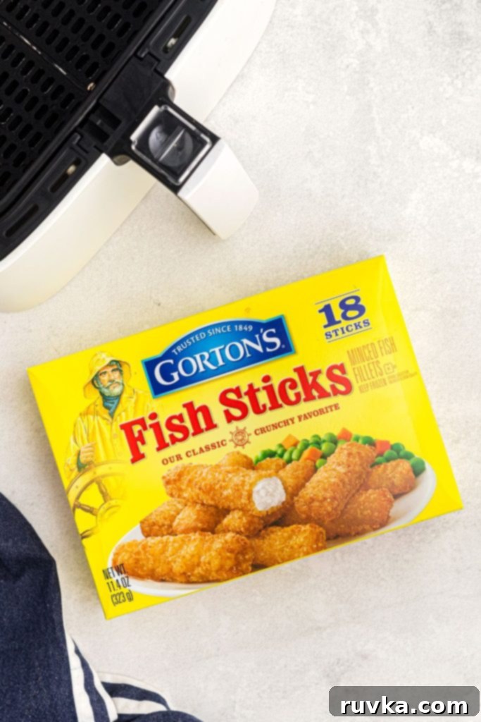 Crispy Air Fryer Fish Sticks 3 Box of Gorton's Fish Sticks on a white marble table with an air fryer basket.