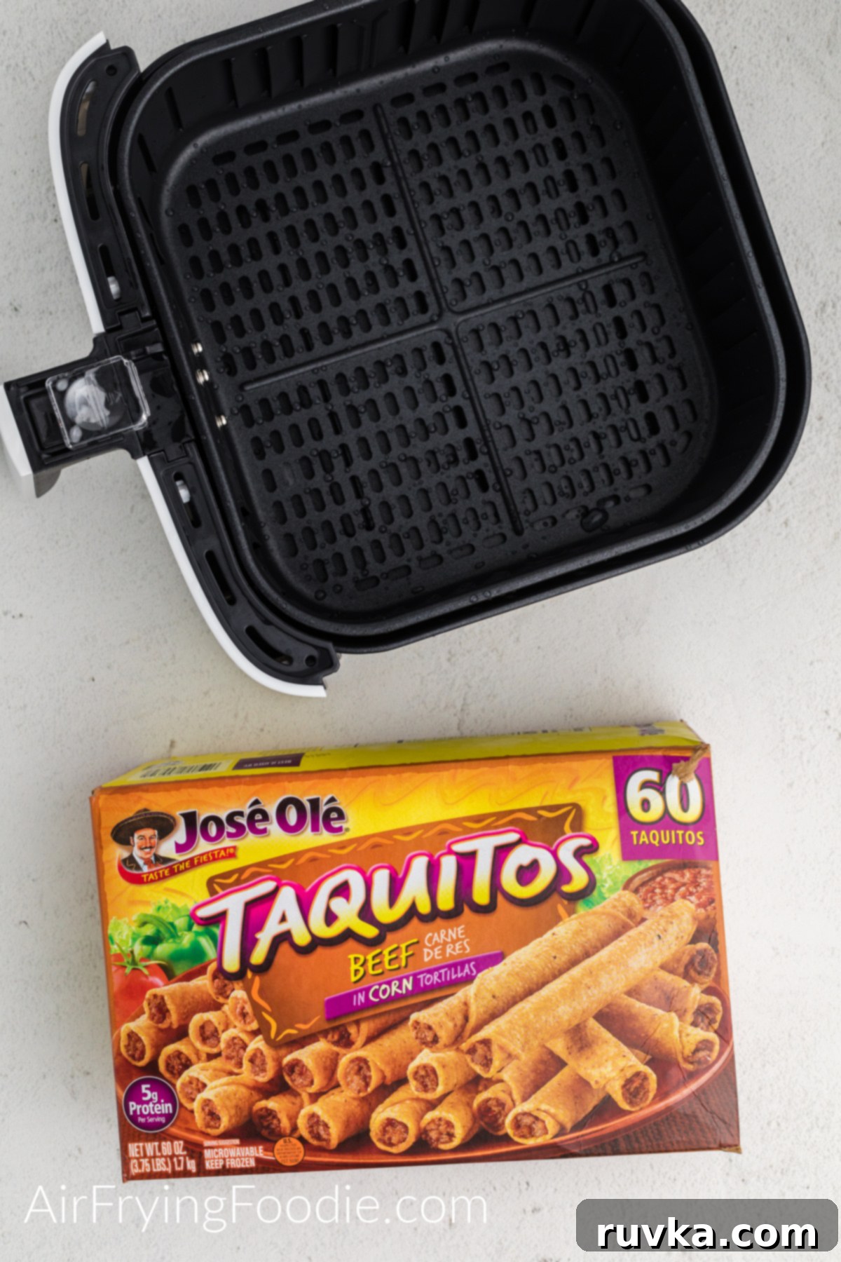 Crispy Air Fryer Frozen Taquitos 3 Box of frozen Jose Ole taquitos and an air fryer basket on a white table.