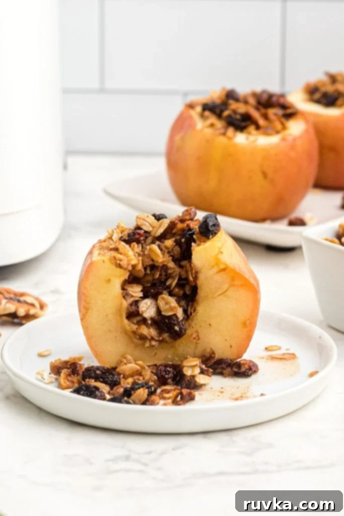 Easy Air Fryer Baked Apples 2 baked apple sliced in half with oats, nuts, and raisins for the filling.