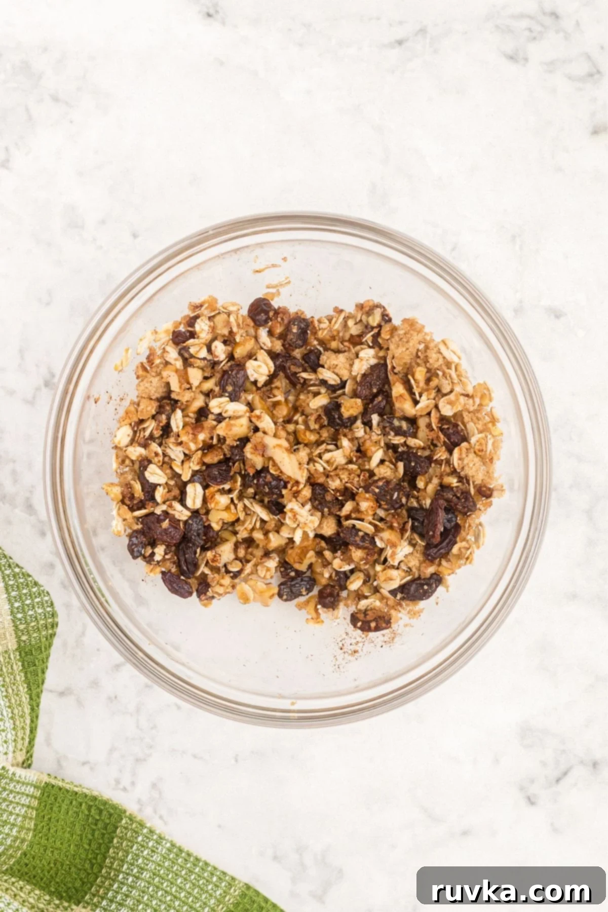 Easy Air Fryer Baked Apples 4 Oats mixture with nuts, raisins and brown sugar in a clear glass bowl