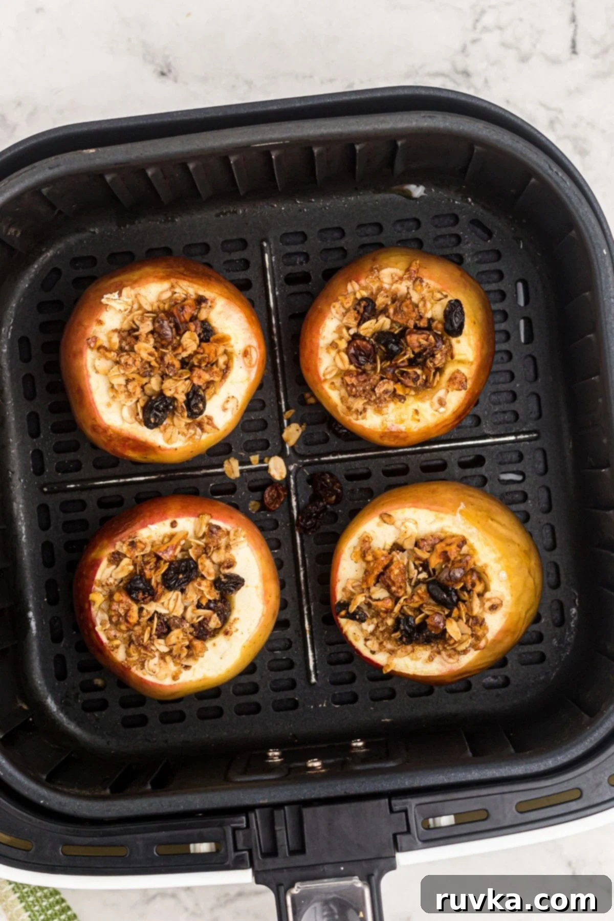 Easy Air Fryer Baked Apples 7 Golden baked apples filled with oats, raisins, nuts mixture after being cooked in the air fryer