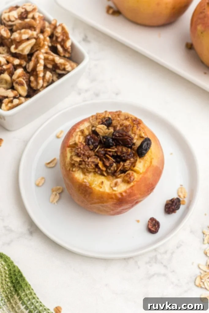 Easy Air Fryer Baked Apples 8 Golden apple baked and stuffed with oat mixture on a white plate