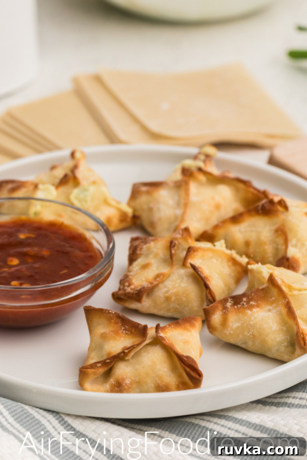 Crispy Air Fryer Crab Rangoon 2 Air fried crab rangoon on a white plate and ready to serve.