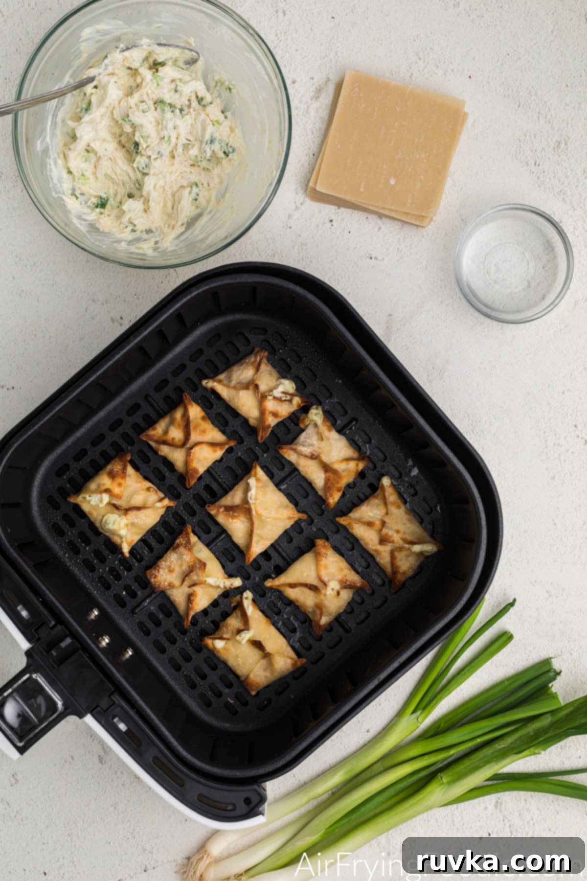 Crispy Air Fryer Crab Rangoon 7 Golden brown air fried crab rangoon in the basket of the air fryer.