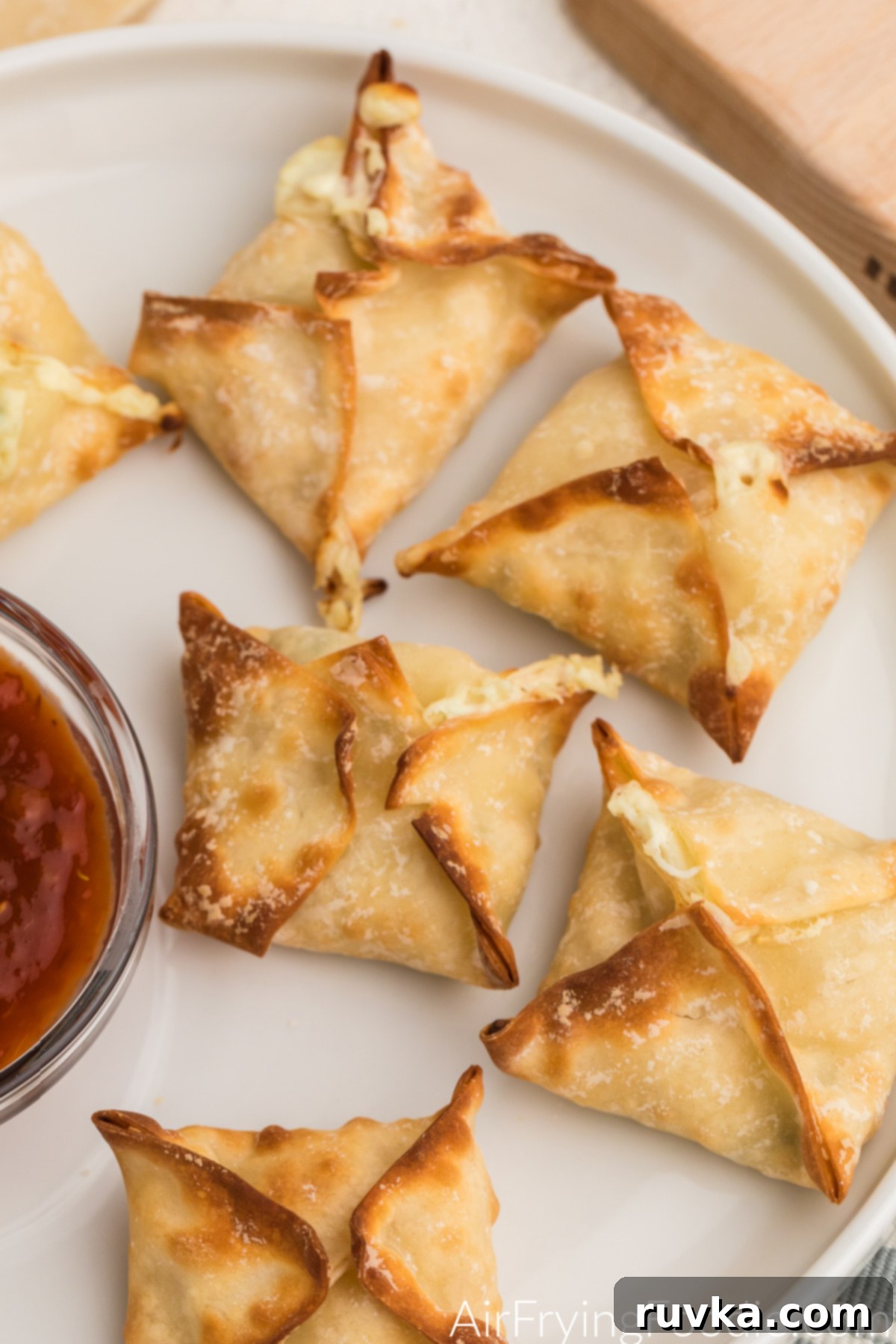 Crispy Air Fryer Crab Rangoon 8 Close up shot of crab rangoon made in the air fryer and served on a white plate.
