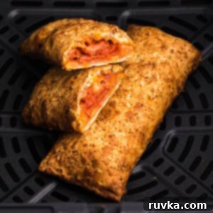 Frozen Food Favorites for the Air Fryer 9 Close up of a crispy hot pocket cooked in an air fryer, with one sliced in half to reveal the warm, melted filling, ready to eat.