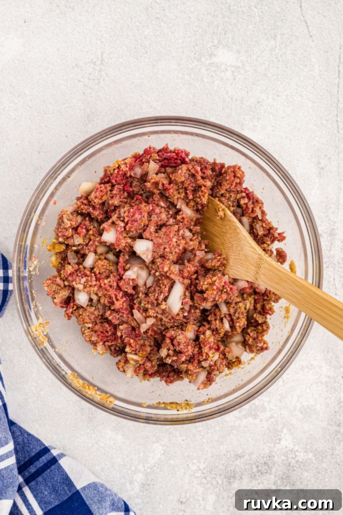 Easy Air Fryer Meatloaf 4 Ground beef being mixed with seasonings, onions, and breadcrumbs