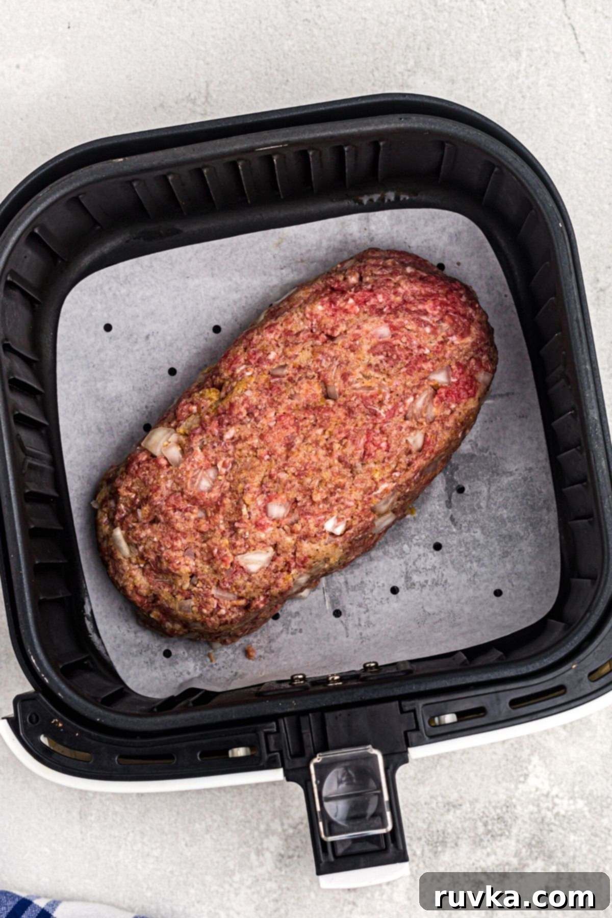 Easy Air Fryer Meatloaf 5 Meat shaped into a loaf in the air fryer basket before being cooked