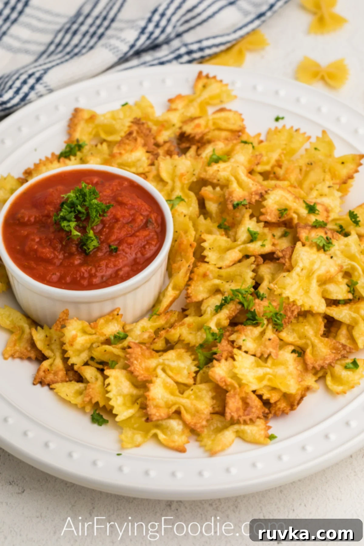 Crispy Air Fryer Pasta Chips 2 Fried Pasta Chips in the air fryer on a white plate served with marinara sauce.