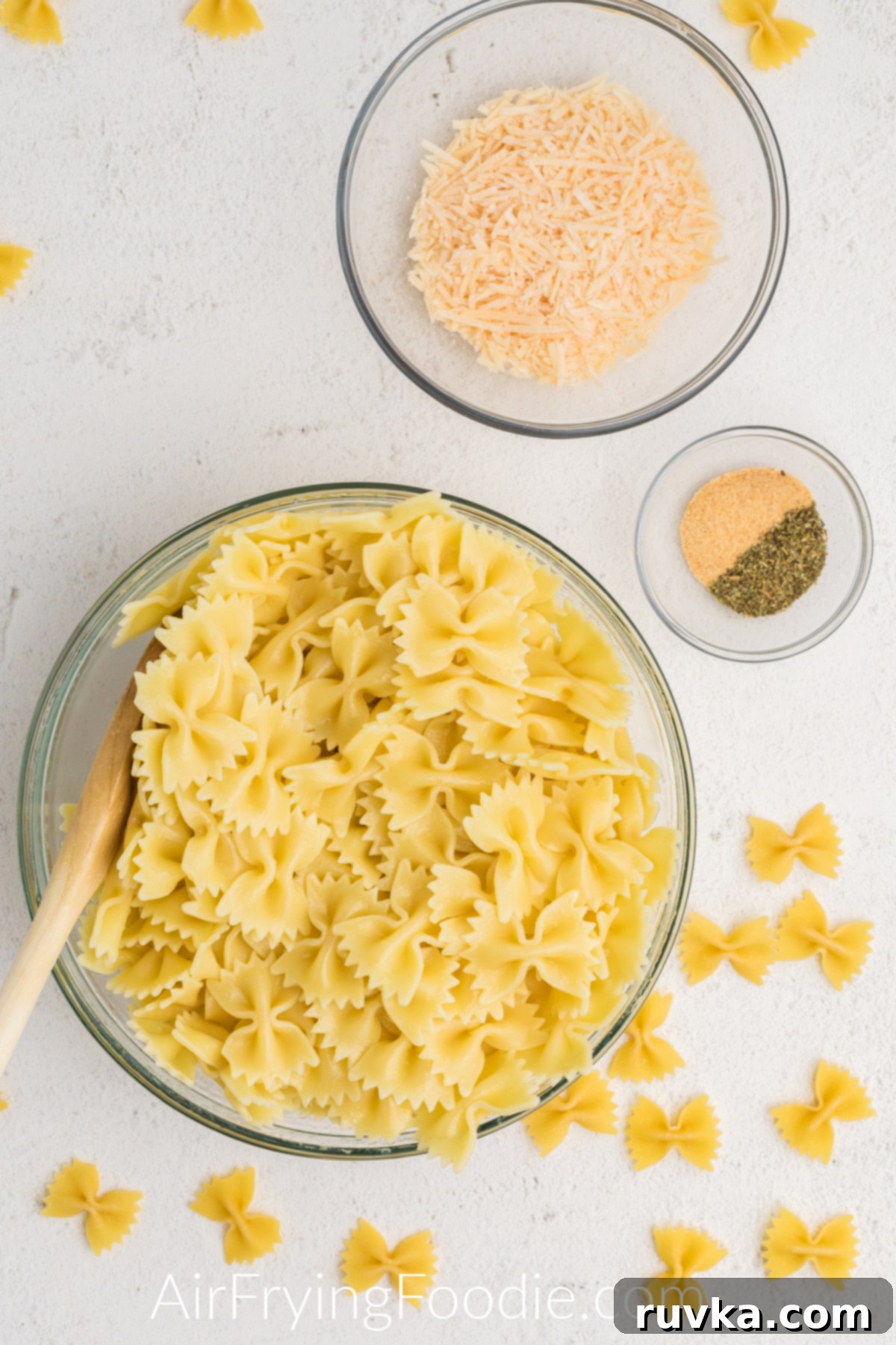 Crispy Air Fryer Pasta Chips 5 Cooked pasta mixed with olive oil in a medium sized mixing bowl.