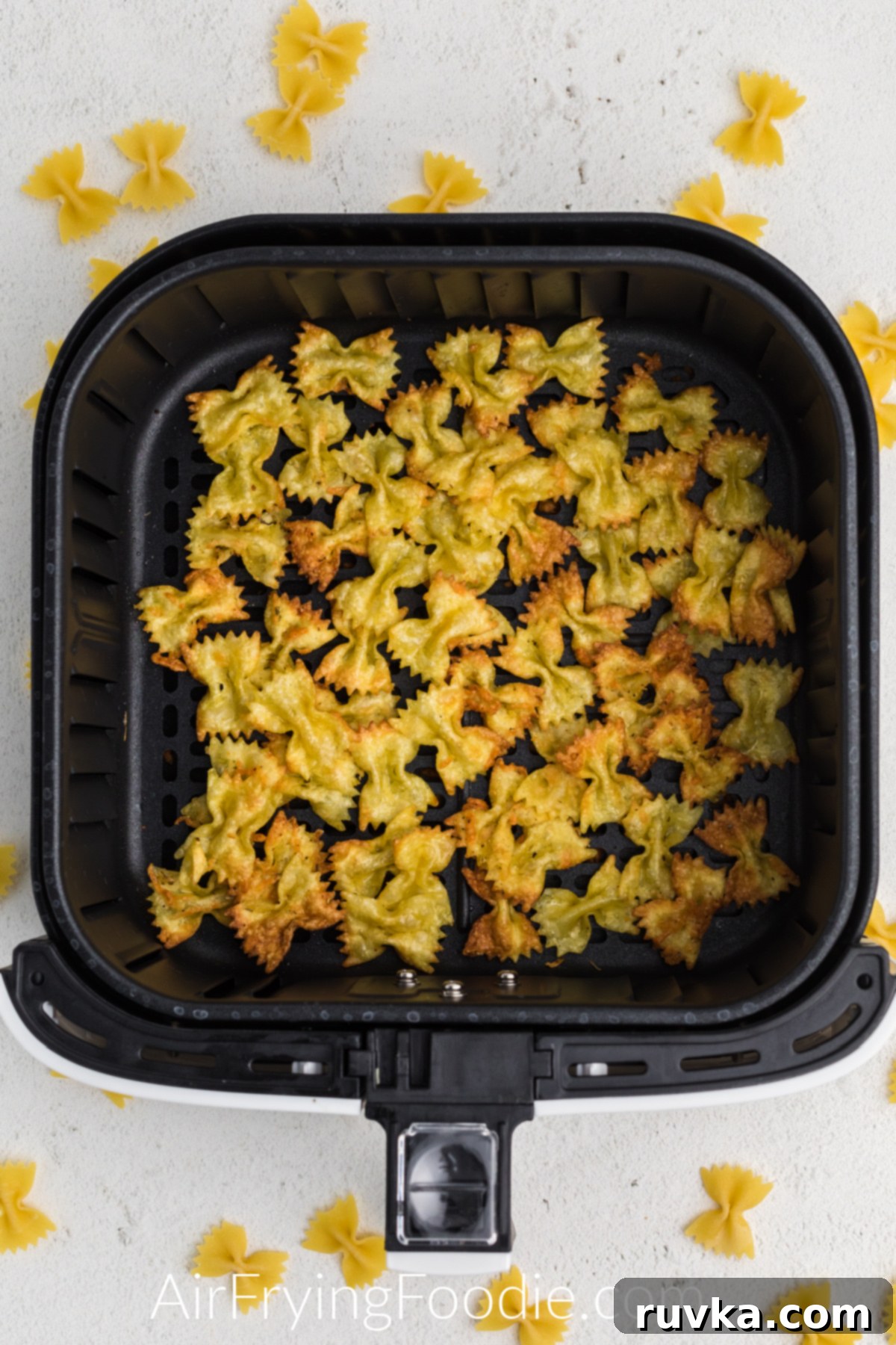 Crispy Air Fryer Pasta Chips 8 Cooked pasta chips in the basket of the air fryer.