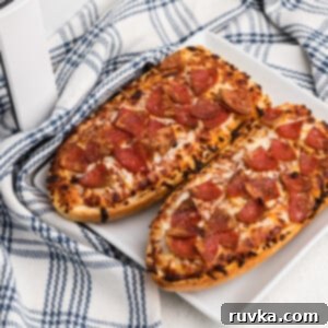 Air Fried French Bread Pizza 7 french bread pizza made in the air fryer and served on a white plate.