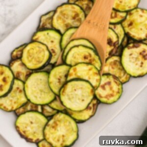 Golden Crispy Air Fryer Zucchini 9 Golden cooked zucchini slices on a wooden spoon