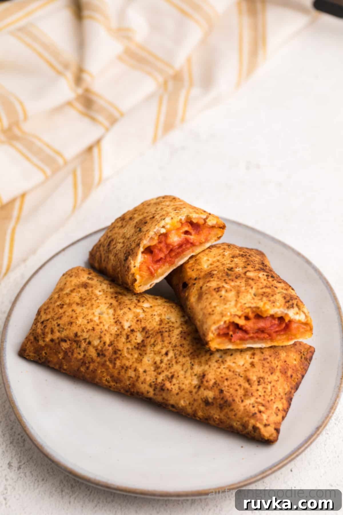 Crispy Air Fryer Hot Pockets 6 Air fried Hot pockets on a plate with one hot pocket cut in half, ready to eat.
