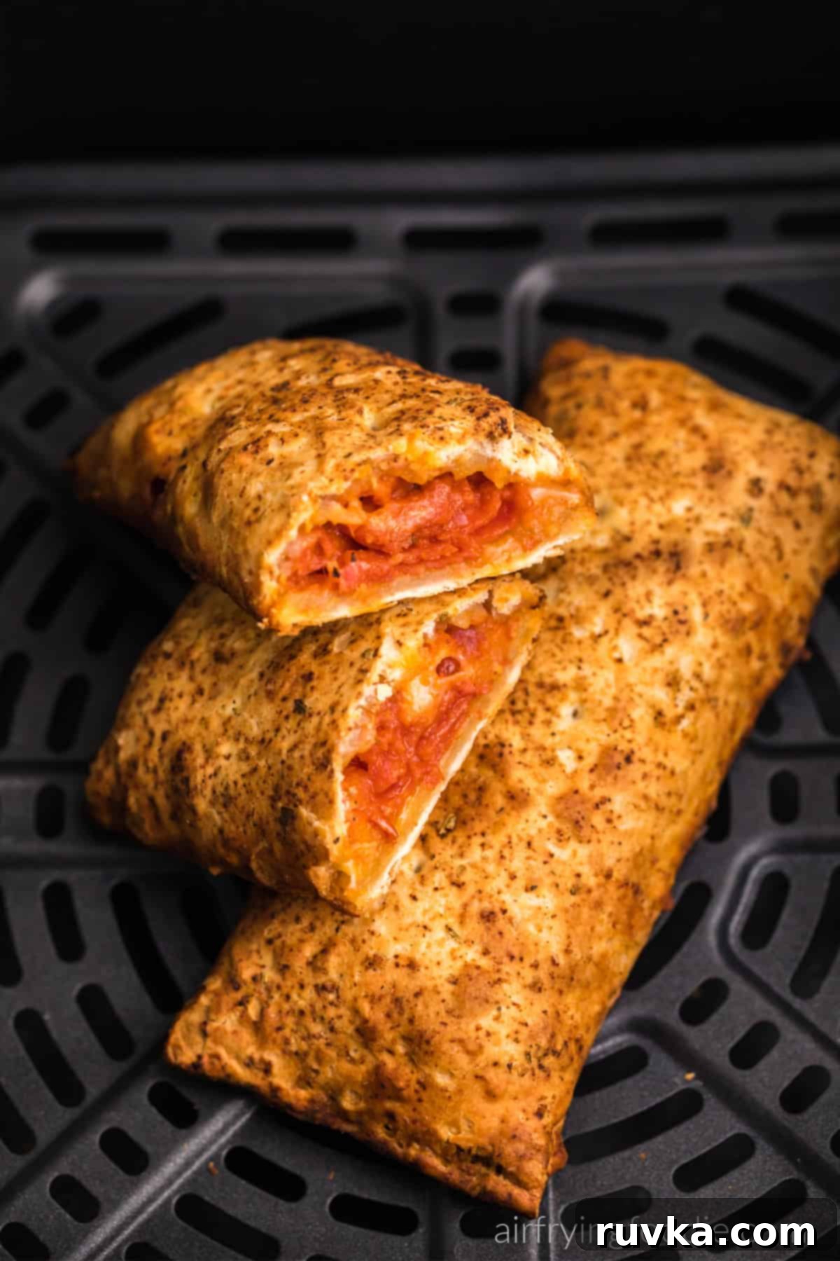 Crispy Air Fryer Hot Pockets 7 Hot pockets in air fryer basket, with one cut in half and ready to serve.