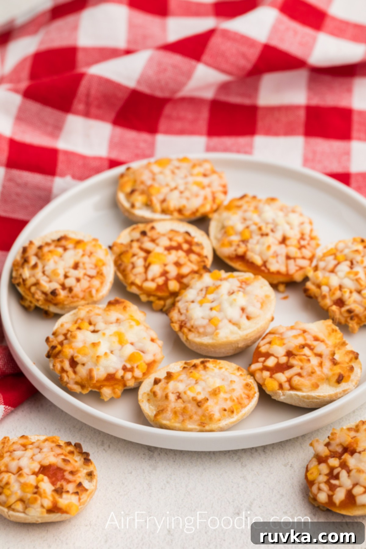 Air Fryer Bagel Poppers 2 Bagel bites made in the air fryer being served on a white plate.