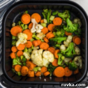 Crispy Air Fried Frozen Vegetables 7 Fully cooked, crispy air-fried frozen vegetables in an air fryer basket, ready to serve.