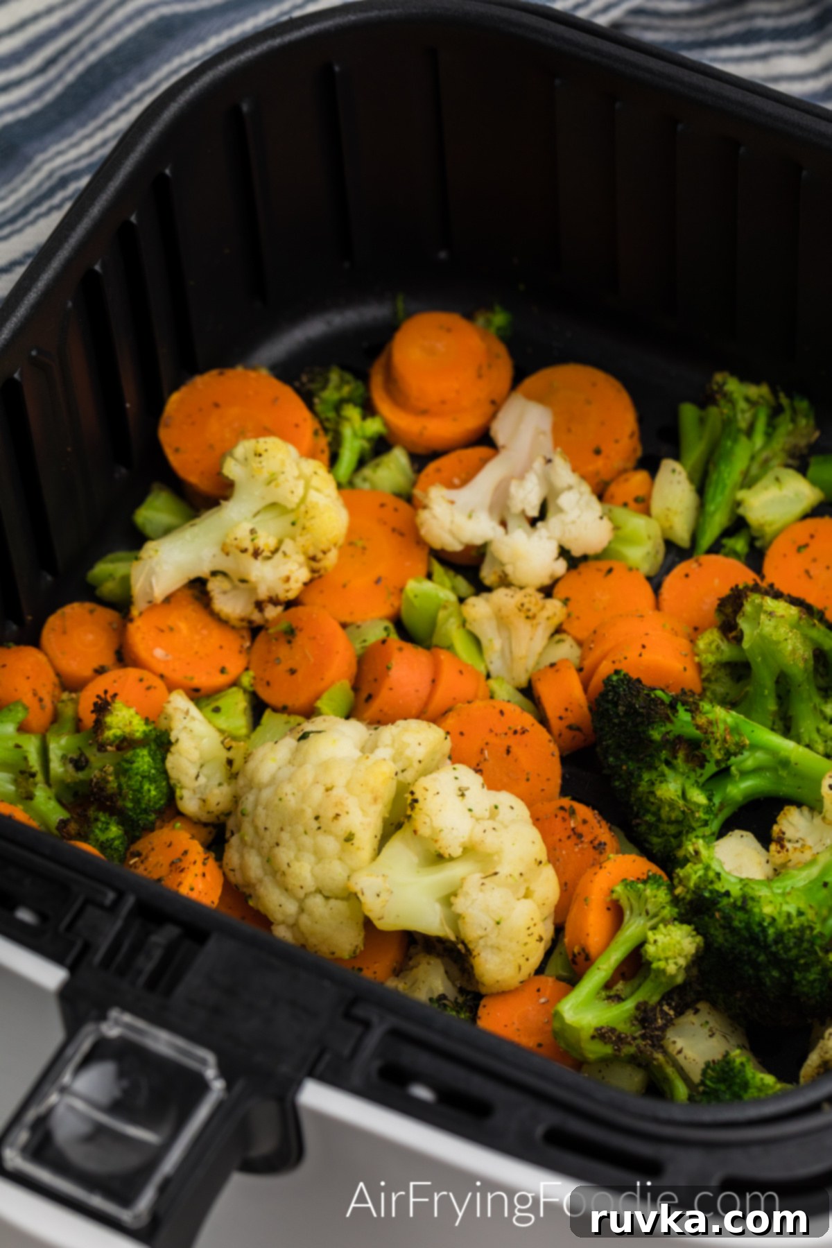 Crispy Air Fried Frozen Vegetables 6 Cooked, golden-brown frozen mixed vegetables in an air fryer basket, steam rising, ready to be served immediately.