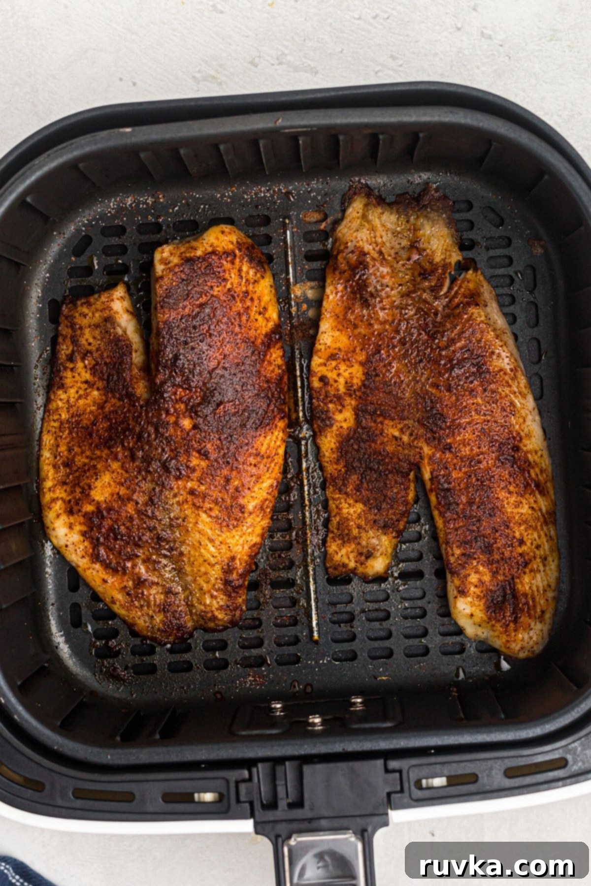 Crispy Air Fryer Tilapia 6 Golden brown cooked tilapia filets in the air fryer basket