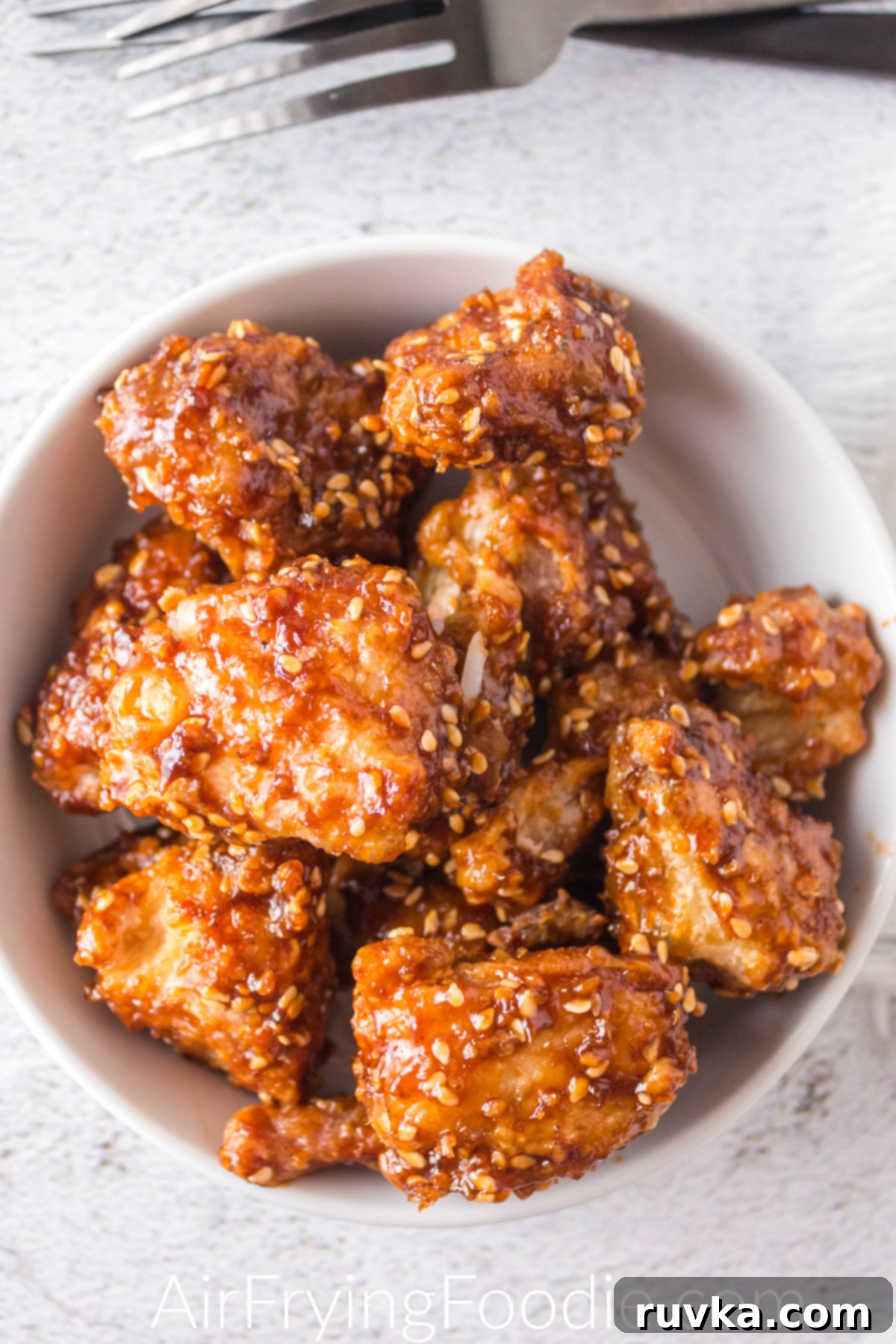 Crispy Golden Air Fryer Sesame Chicken 2 Air fried sesame chicken in a white bowl ready to serve.