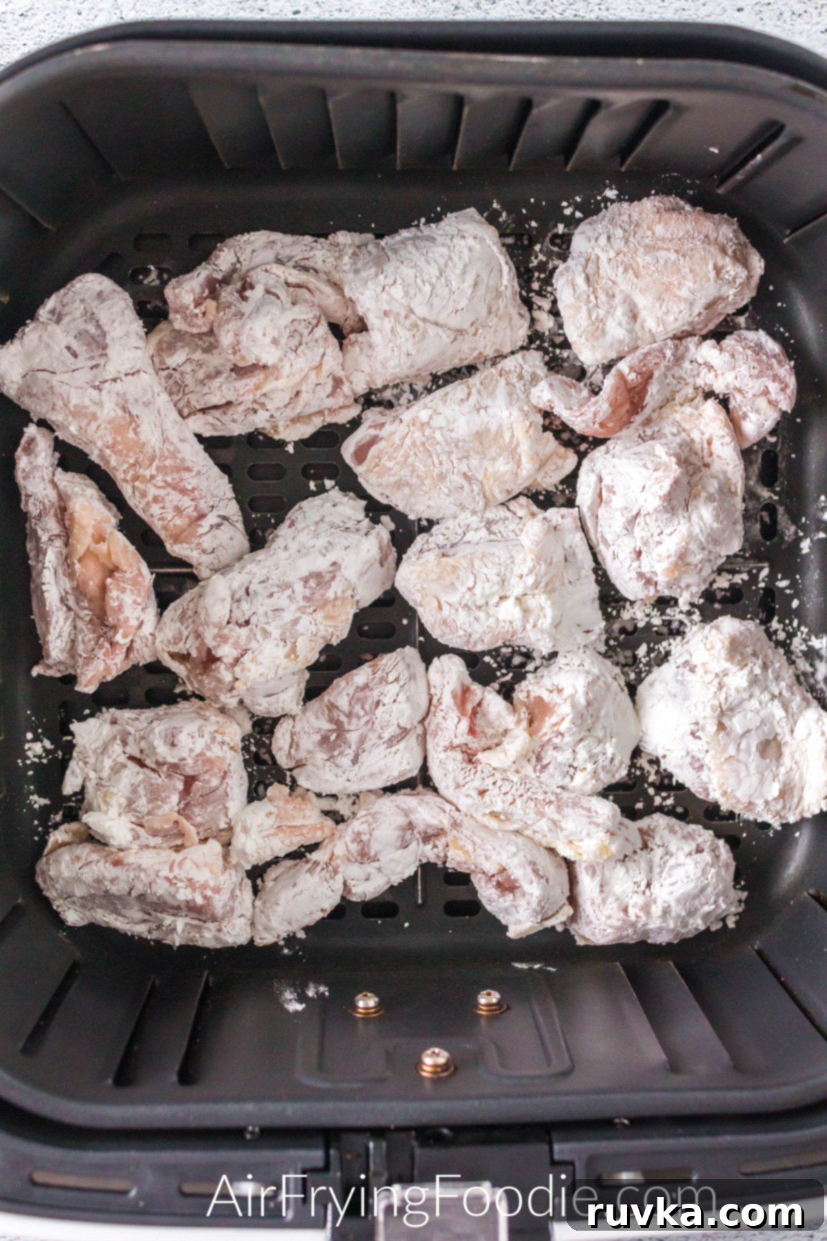 Crispy Golden Air Fryer Sesame Chicken 5 Coated chicken in the basket of the air fryer