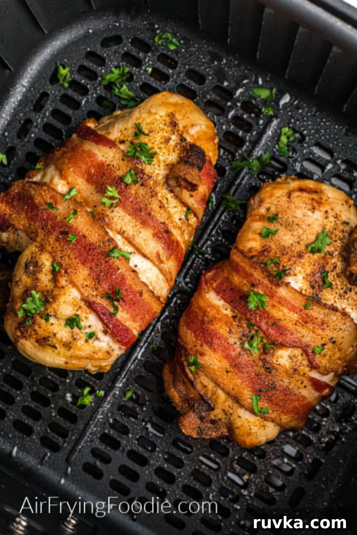 Super Bowl Air Fryer Snacks 11 Succulent bacon-wrapped chicken, cooked to perfection, showcasing crispy bacon and tender chicken in an air fryer basket.
