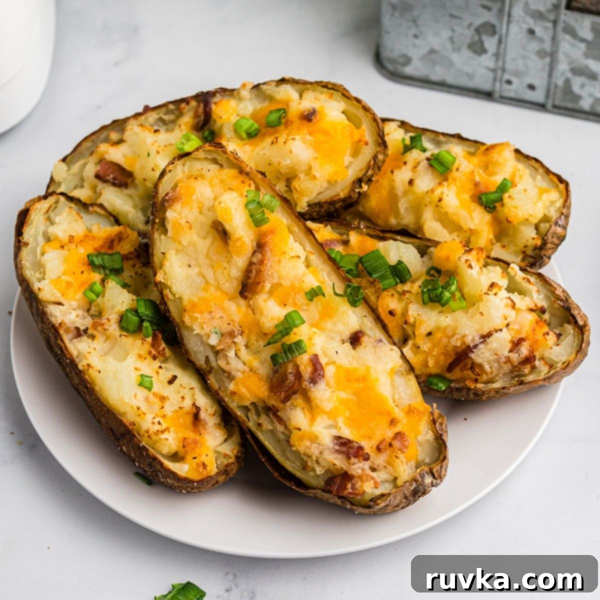 Super Bowl Air Fryer Snacks 23 Creamy and cheesy twice-baked potatoes, perfectly cooked in the air fryer, served warm on a plate.