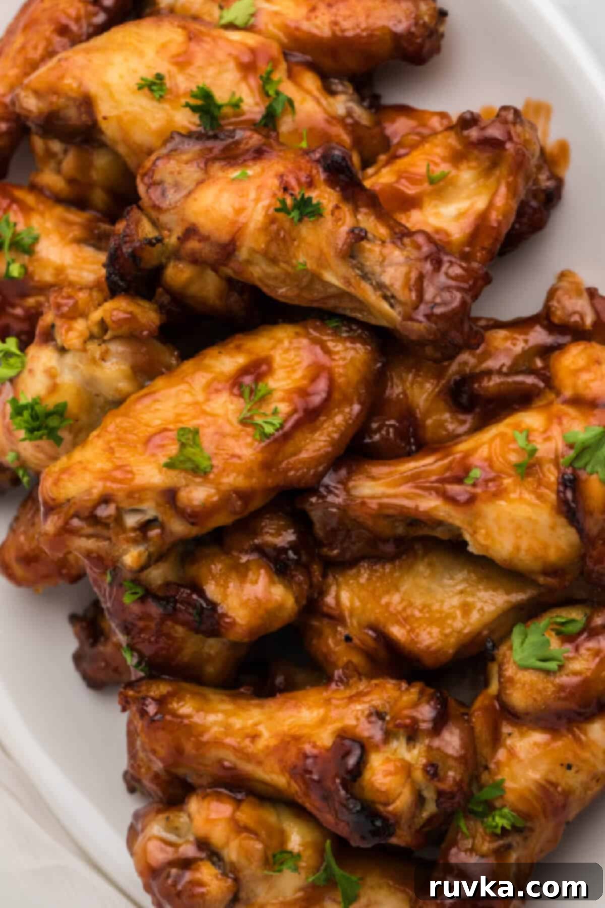 Super Bowl Air Fryer Snacks 6 Sticky and savory BBQ chicken wings arranged on a white platter, ready for a delicious game day spread.
