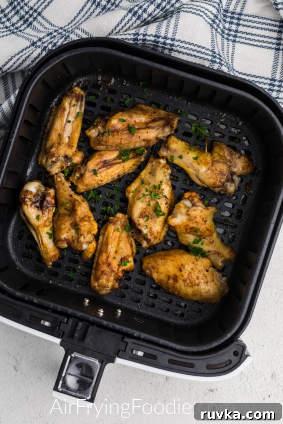 Super Bowl Air Fryer Snacks 7 Seasoned frozen chicken wings perfectly cooked to a golden crisp in an air fryer basket.