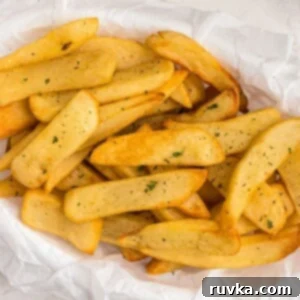 Crispy Air Fryer Veggies 17 Close up photo of golden crispy steak fries cooked and in a basket, garnished with parsley flakes.