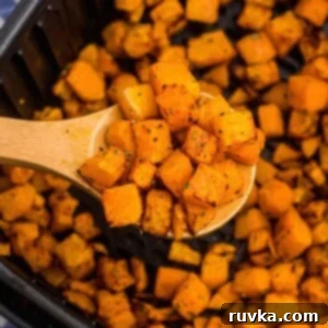 Crispy Air Fryer Veggies 5 Wooden spoon with cooked squash over the air fryer basket.