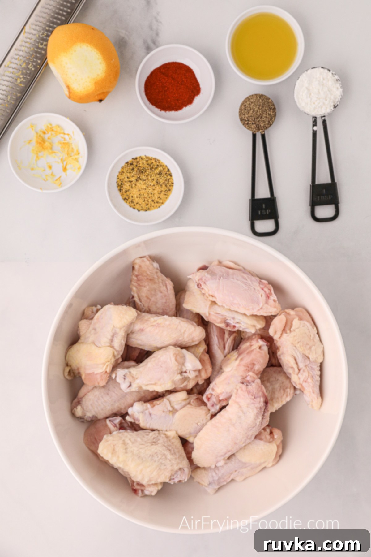 Zesty Air-Fried Lemon Pepper Wings 3 White countertop displaying all the fresh and dry ingredients needed to prepare delicious lemon pepper wings in an air fryer.