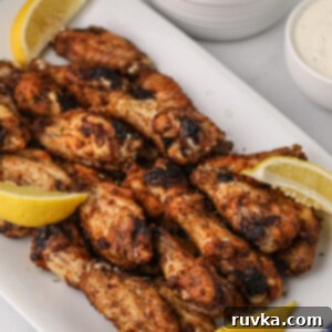 Zesty Air-Fried Lemon Pepper Wings 8 Air Fried Lemon Pepper Wings on a white plate with lemon slices.