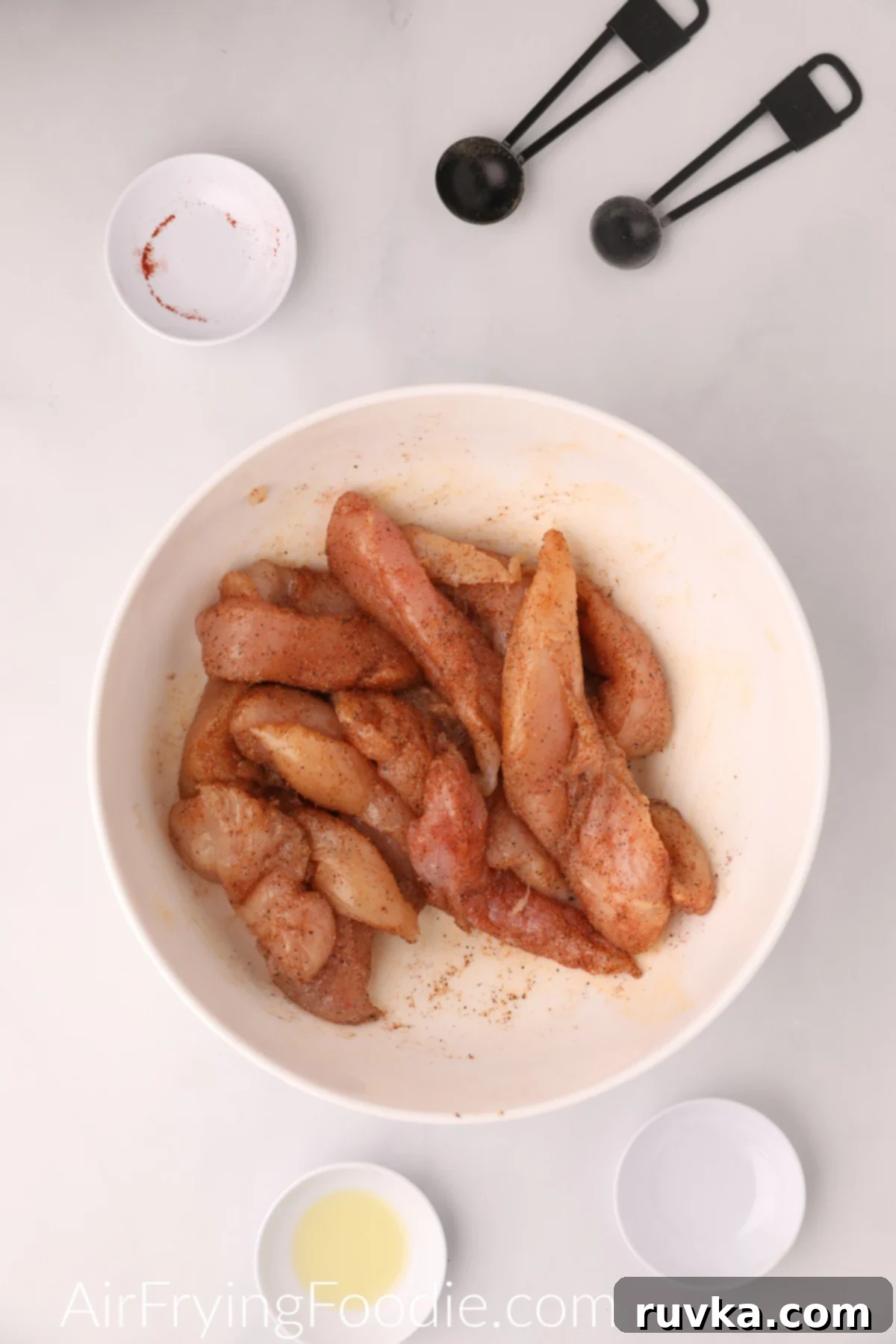 Naturally Crispy Air Fryer Chicken Tenders 4 Seasoned chicken tenders in a bowl ready to be cooked in the air fryer.