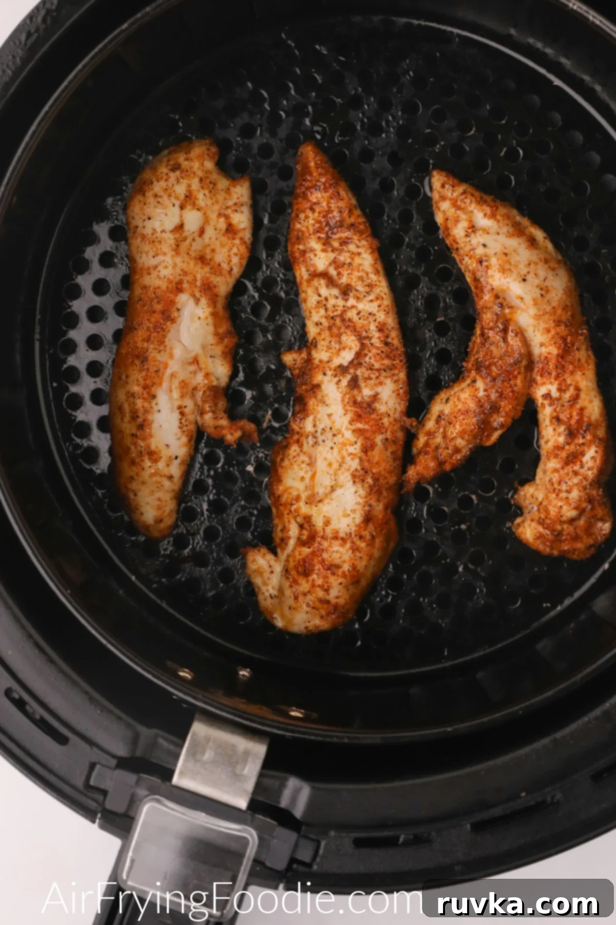 Naturally Crispy Air Fryer Chicken Tenders 5 Cooked and seasoned naked chicken tenders in the air fryer basket, ready to serve.