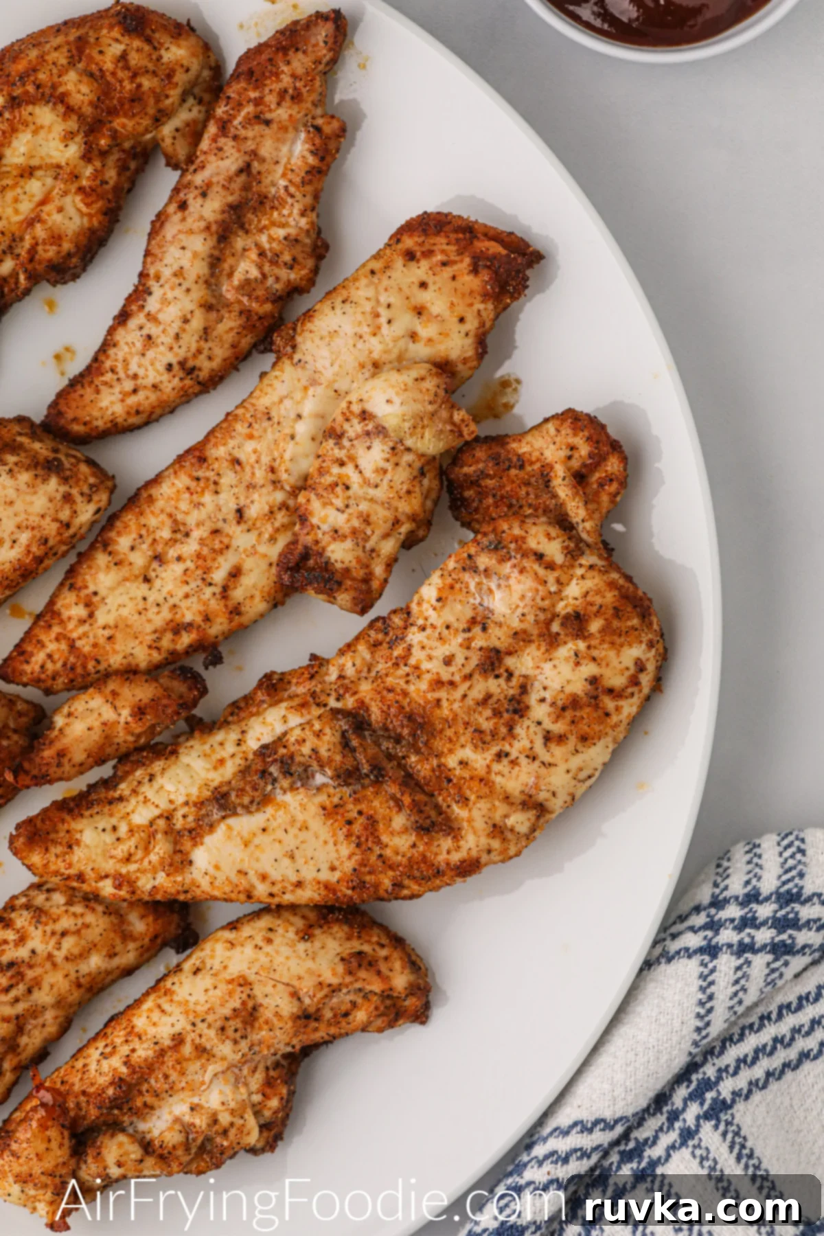 Naturally Crispy Air Fryer Chicken Tenders 7 Fully cooked chicken tenders on the white plate and ready to eat.