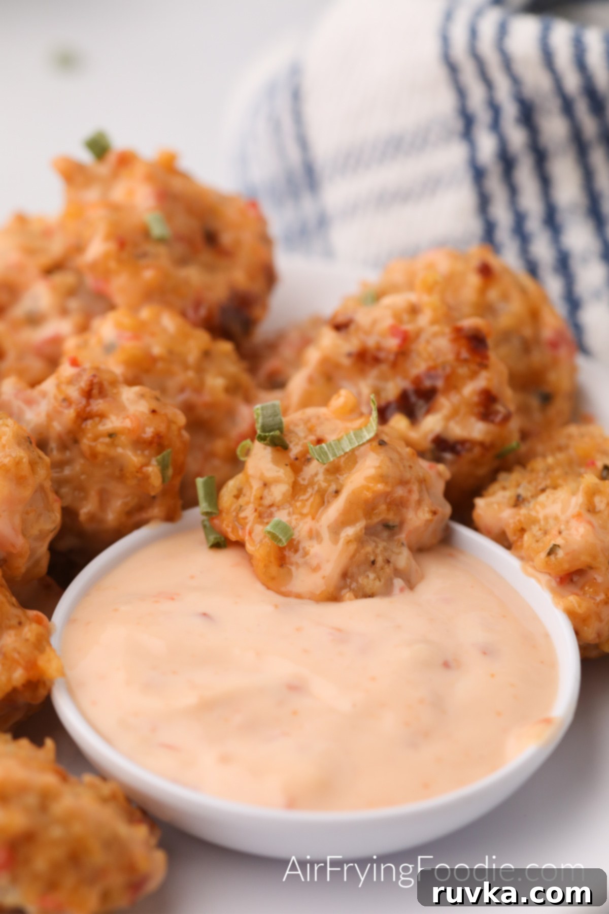 Crispy Air Fryer Bang Bang Shrimp 2 Bang Bang Shrimp made in the air fryer and served on a white plate with dipping sauce, ready to eat.