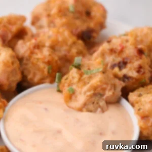 Crispy Air Fryer Bang Bang Shrimp 10 Air Fryer Bang Bang Shrimp in dipping sauce and on a white plate.